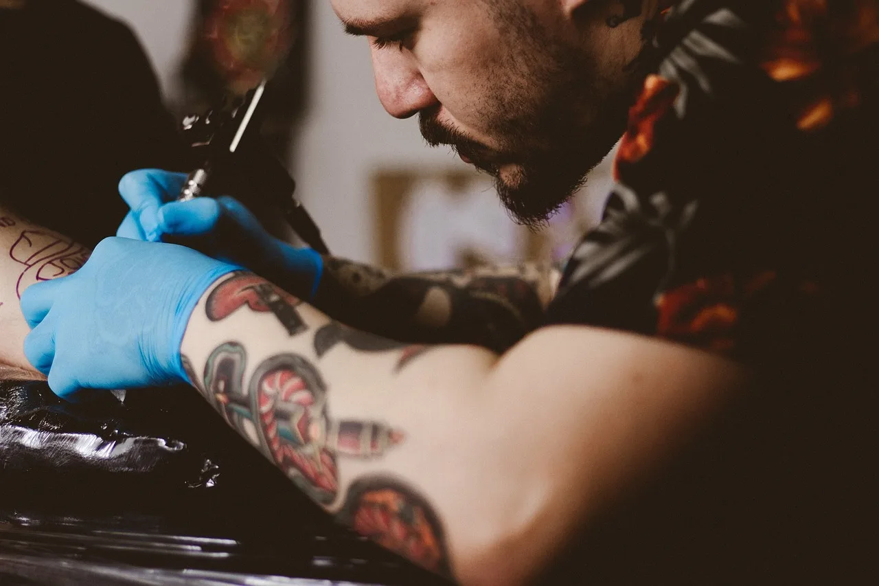 hand, glove, shoulder, arm, tattoo, art, people, man, male, tattoo, tattoo, tattoo, tattoo, tattoo. Tattoo studio daily run sheet: desk and artist tasks from opening to closing